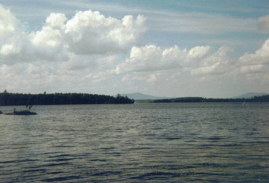 Lake Webb in Weld, Maine with large clouds above it